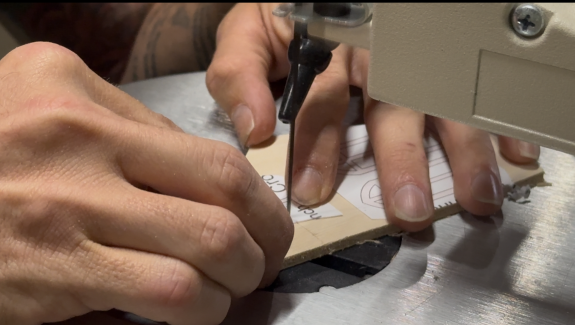 A scroll saw cutting an intricate wooden pattern